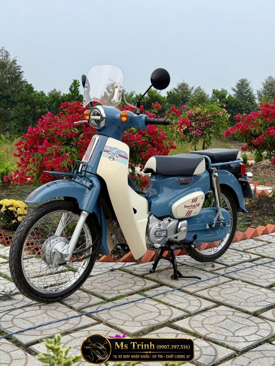 Tổng thể Honda Super Cub 50 Final Edition custom phụ kiện nổi bật giữa vườn hoa đầy màu sắc